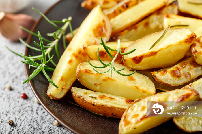 Fresh baked red potatoes with rosemary and garlic on brown plate