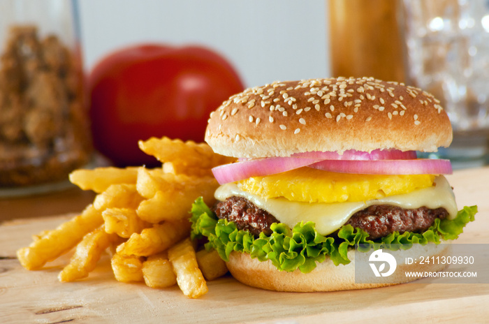 A served hamburger with a pineapple topping in the middle.