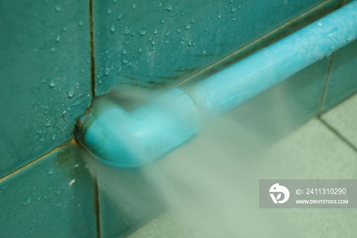 water splashing from broken plumbing blue polythene pipe line in bathroom