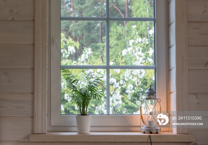 White window with mosuito net in a rustic wooden house