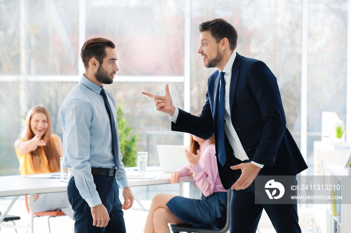 Young man bullying his colleague at work