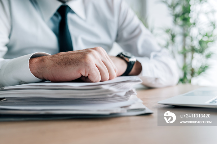 Business archive, businessman with stack of company reports and documentation