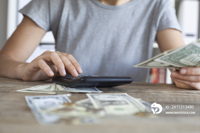 Close up of woman with calculator counting money