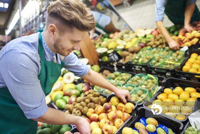 Sales clerk grabbing the box of fruits