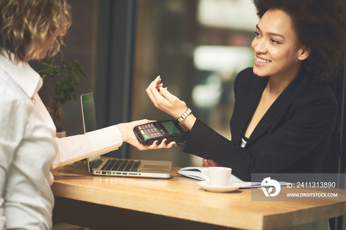 Mixed race woman using smartpay on her smart watch