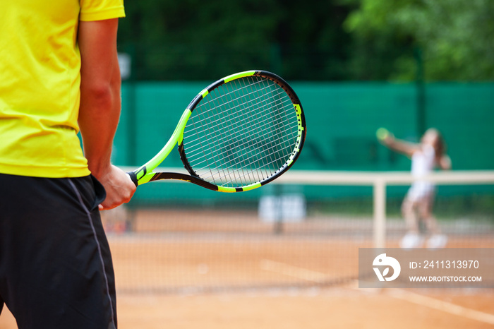 Midsection of male tennis player holding the racket.