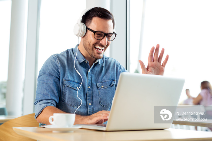 Young freelancer listening music and working at the coffeehouse