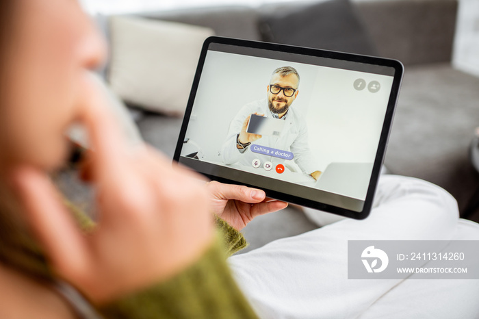 Woman talking with a doctor online using digital tablet, feeling bad at home. Concept of telemedicine and patient counseling online