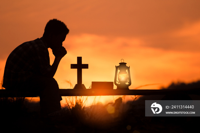 boy praying and reading holy bible on wood , christian silhouette concept.