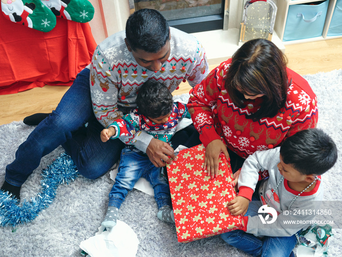 Family with sons opening Christmas presents