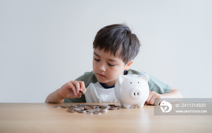 Child boy putting coins into piggy bank, Child counting saving money, Young kid holding coin on his hands, Children learning financial responsibility and planning about saving money for future