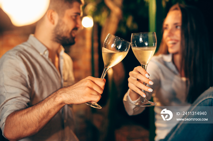 romantic couple drinking wine on backyard decking . evening scene