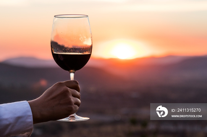 Glass of wine under sunset on the mountain