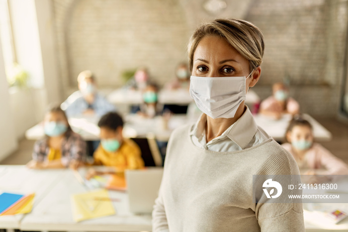 Elementary school teacher with protective face mask in the classroom.