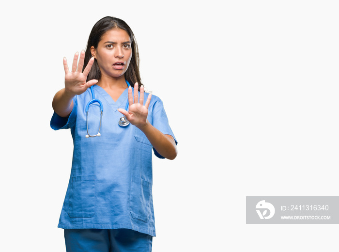 Young arab doctor surgeon woman over isolated background afraid and terrified with fear expression stop gesture with hands, shouting in shock. Panic concept.