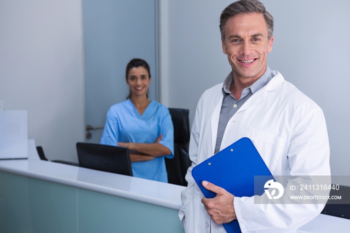 Portrait of smiling doctors standing against wall