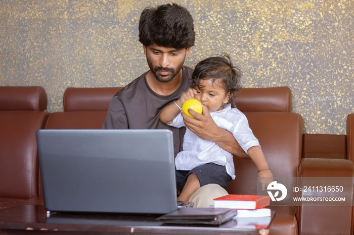 Young father with his little son working on laptop at home - Concept of work form home or wfh reality, People Lifestyles and technology