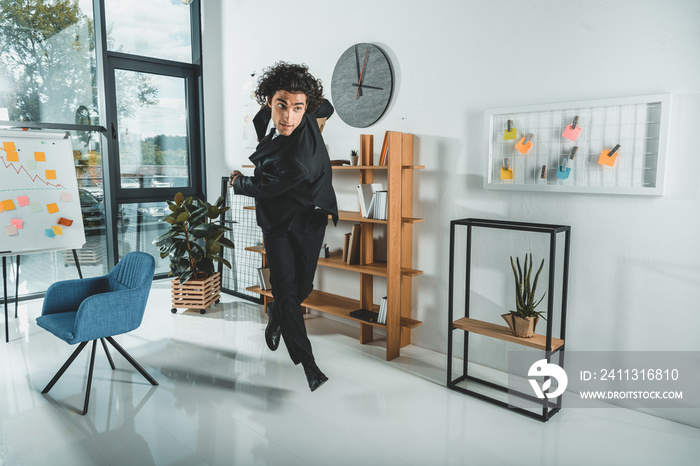 hurrying businessman with folders running in office not to miss deadline at work