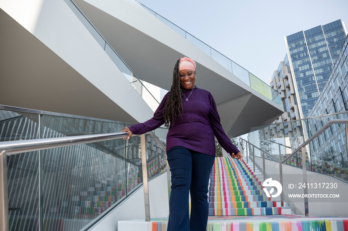 Portrait of beautiful woman with dreadlocks standing on colorful steps