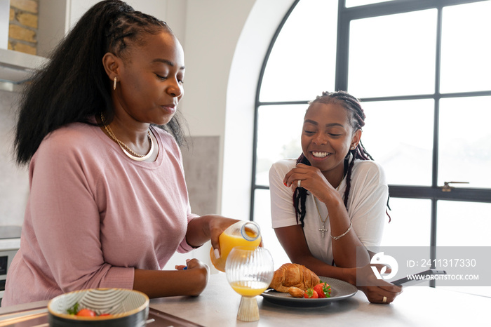 Lesbian couple eating breakfast in kitchen