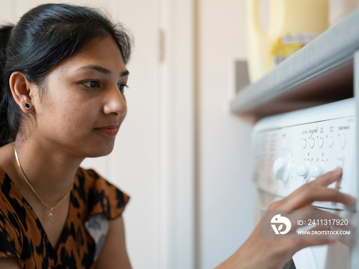 Young woman doing laundry at home