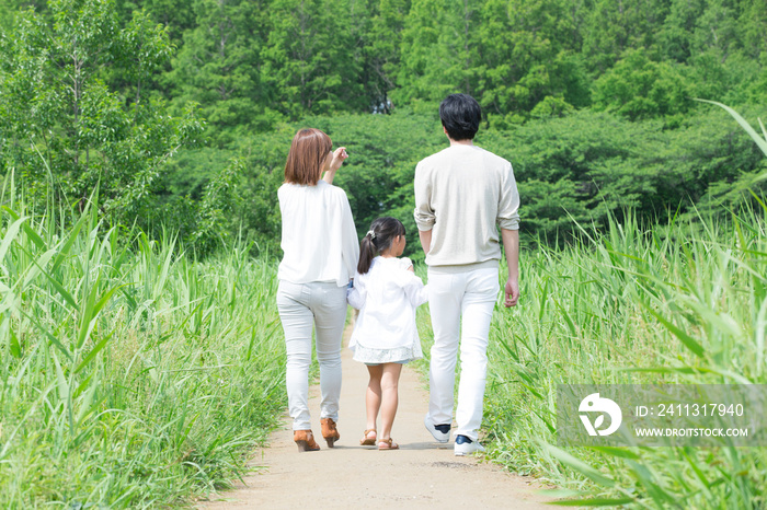 手を繋いで歩く親子の後ろ姿