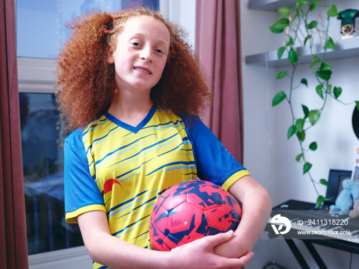 Girl in sports clothing holding volleyball