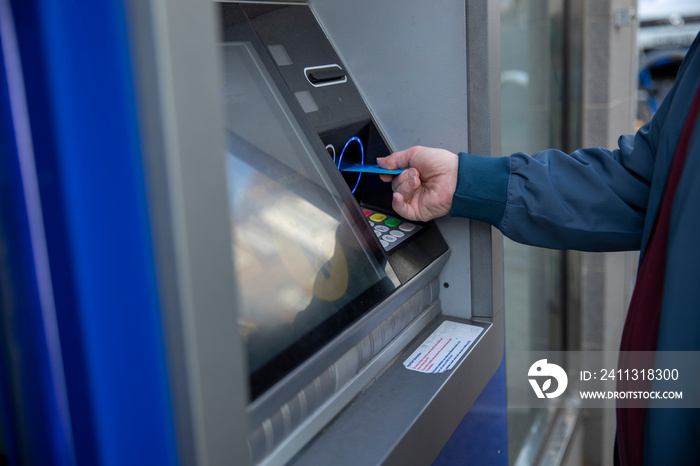 Man using debit card in cash machine, close up