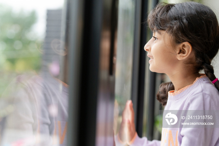 Little girl looking out window