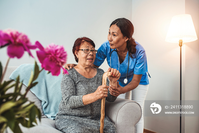 Caregiver, carer hand holding elder hand woman in hospice care. Philanthropy kindness to disabled concept.Public Service Recognition Week. Attentive young doctor talks with female patient