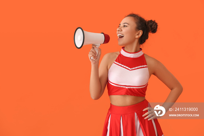 Beautiful young cheerleader with megaphone on color background