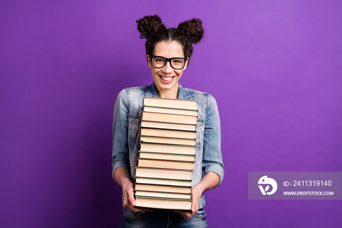 Photo of funny student lady holding many books carry literature home in love with reading wear specs casual denim outfit isolated purple color background