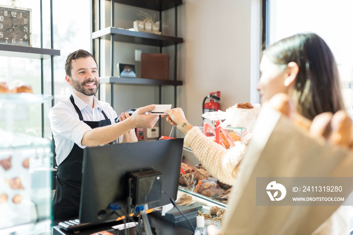 Smiling Worker Accepting Payment In Bakery Store