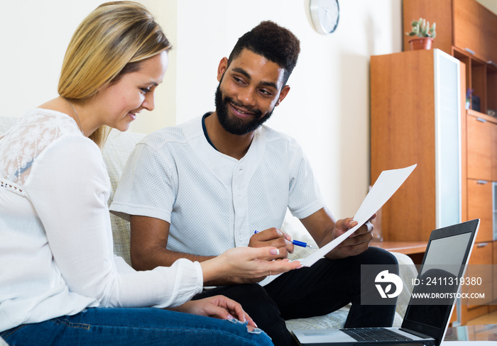 Interracial couple discussing banking offer for mortgage at home