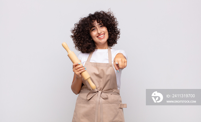 young pretty woman chef pointing at camera with a satisfied, confident, friendly smile, choosing you