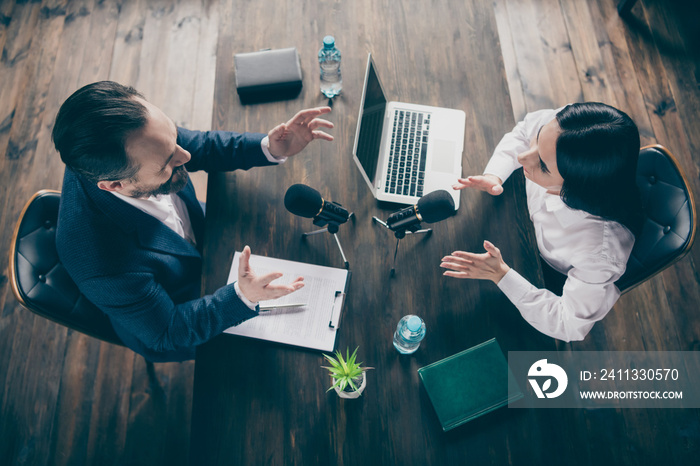 High angle above view photo of two business people journalism press conference ask questions speak mic report politics information sit opposite modern office indoors