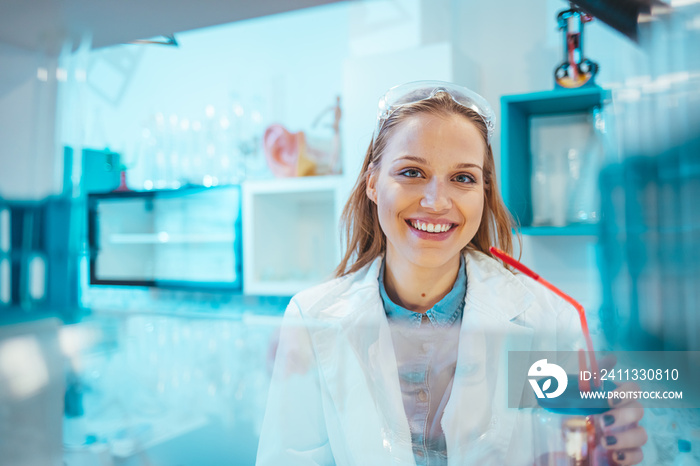 Modern laboratory interior. Woman working on medical samples in background. Young female scientist standing in her lab. Young Female Scientist Working in The Laboratory