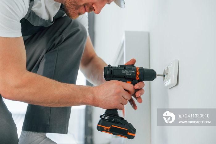 Close up view. Repairman is working indoors in the modern room