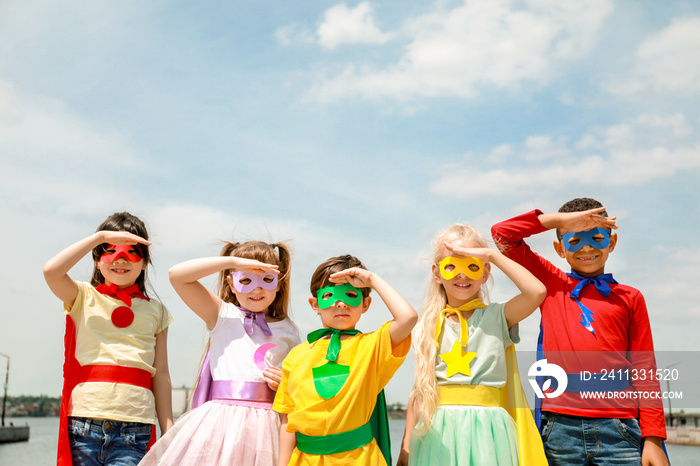 Cute little children dressed as superheroes outdoors