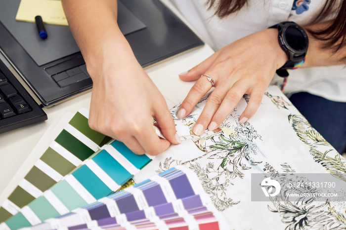 Female fashion designer holding color samples choosing fabric textile at workplace, dressmaker or tailor checking fabric quality, close up view