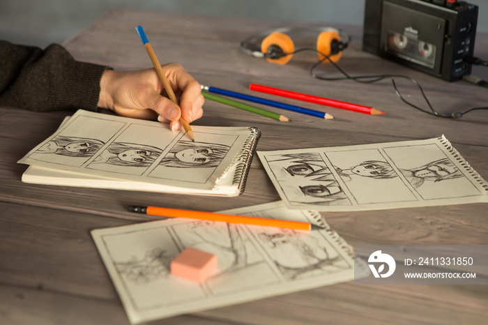 Artist drawing an anime comic book in a studio. Wooden desk, natural light. Creativity and inspiration concept.