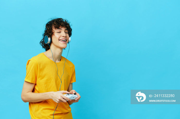 man plays with joystick in yellow t-shirts isolated backgrounds