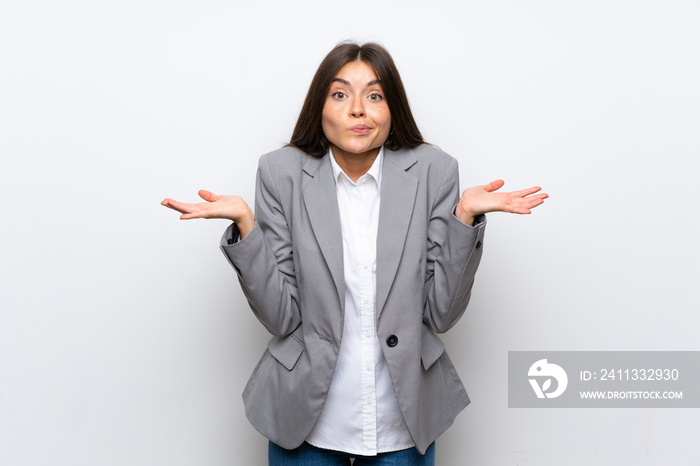 Young business woman over isolated white background having doubts while raising hands