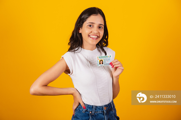 beautiful brazilian woman holding driver’s license document.