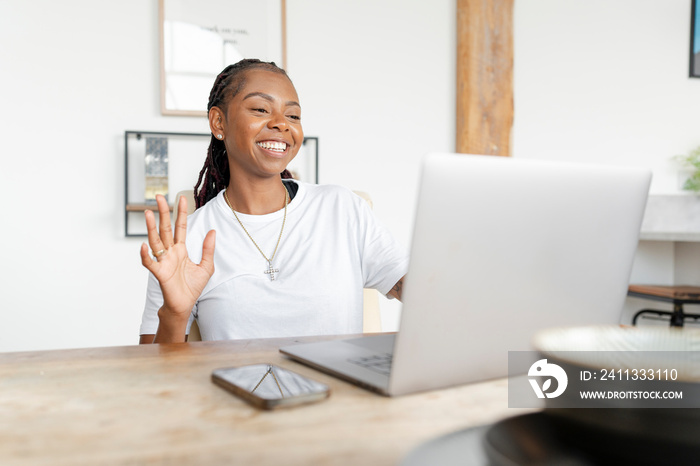 Cheerful woman working on laptop at home