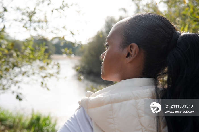 Rear view of woman standing on riverbank