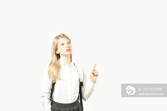 Portrait of a smiling young woman pointing up, isolated on white background