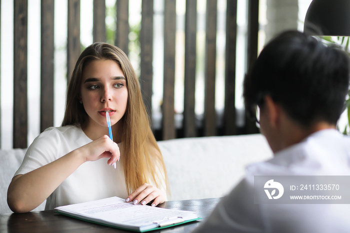 A pair of young people talking at the office