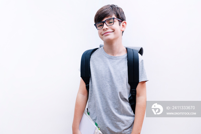 Beautiful student kid boy wearing backpack holding books over isolated white background