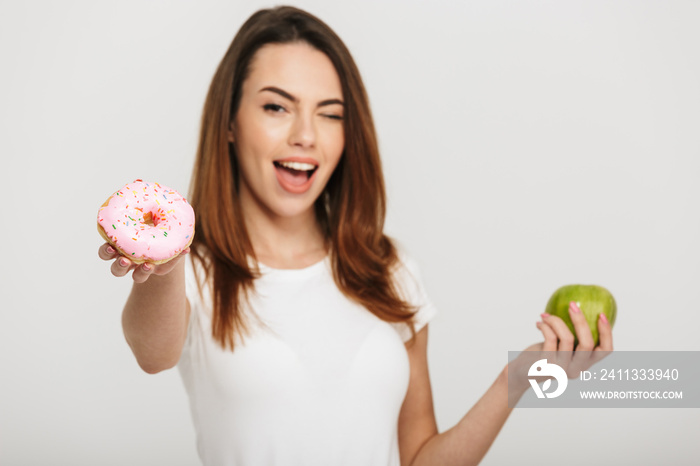 Portrait of a cheerful young girl giving a donut